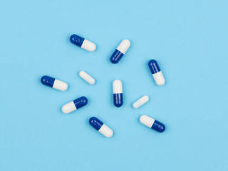 Medicinal capsules on a blue background.