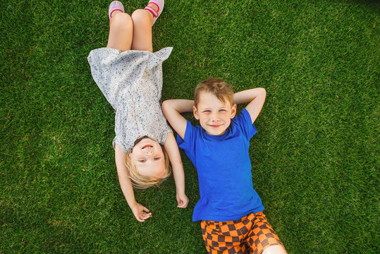 children lying on the green grass in the Park. The interaction of the children