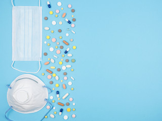 Medical mask, dust mask and pills on a blue background.