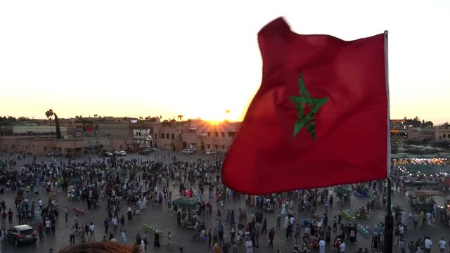 sunset shot of the moroccan flag at the main bazaar in marrakesh, morroco