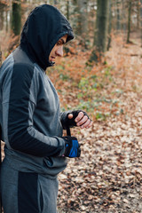 Young fitness man preparing for training workout outdoor.