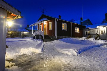 petite maisons rouge dans un village du nord arctique avec neige et ciel bleue nocturne