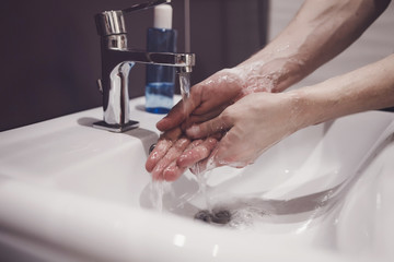 man showing hand hygiene washing hands with soap in hot water for coronavirus germs spreading...