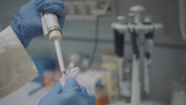 researcher pipetting DNA sample into eppendorf vial in laboratory
