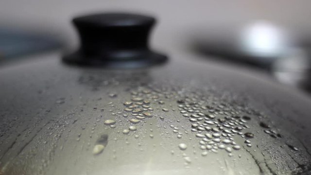 Cooker condensation steam droplets dripping, closeup 