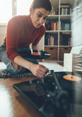 Young woman playing music on turntable. Leisure time, hobbies