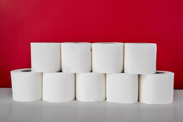 Consumer buying panic about covid-19. Toilet paper rolls on red background. Coronavirus outbreak concept.