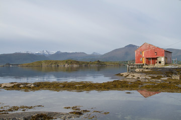 Rotes Holzhaus an einem Fjord