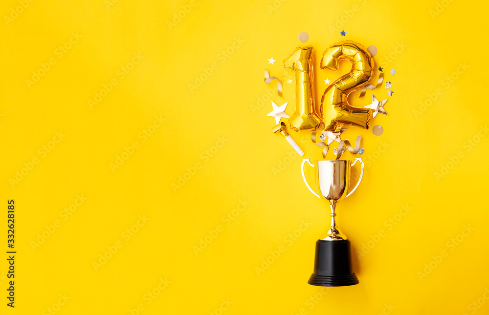 Wall mural Number 12 gold anniversary celebration balloon exploding from a winning trophy