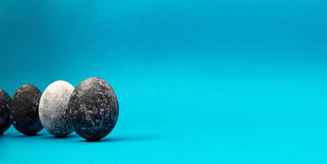 Painted cosmic dark blue eggs with white dots on blue background. Happy easter concept. Copy space