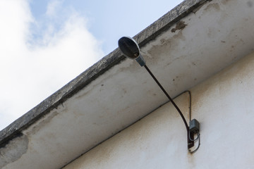 old lamppost without light bulb on a facade