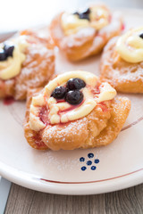 The Neapolitan pastry is called zeppola di san giuseppe, with black cherries, lemon cream with vanilla - Street Food Naples - Italy