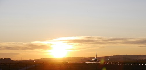Naklejka premium Plane taking off into the sunset