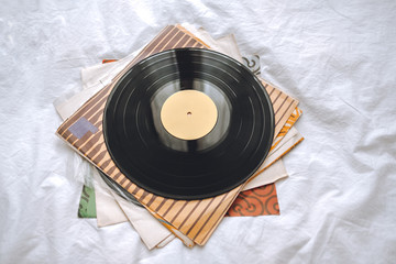 Fototapeta premium Old vinyl records on a white bed. minimalism