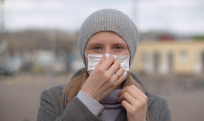 Handsome woman puts on protective mask