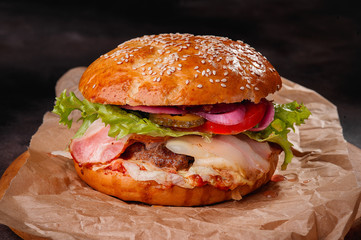 juicy burger with bacon on craft paper.