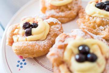 The Neapolitan pastry is called zeppola di san giuseppe, with black cherries, lemon cream with vanilla - Street Food Naples - Italy