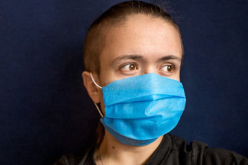 The man in the medical mask looks away and hopes that the coronavirus pandemic will end soon