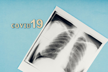 Coronavirus, covid-19. The inscription covid-19 and x-ray snapshot of the lungs on a blue background. Self-isolation and quarantine, pneumonia. Diagnosis of lung diseases.