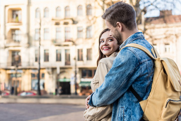 Obraz premium Girl and man hugging, smiling and looking at each other in city