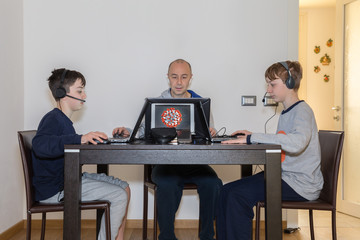 Man Works from Home and Children and Teens Studying at Home with PC Because of the Coronavirus
