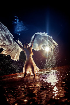 Beautiful white angel is dancing in the water drops.