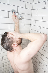 Caucasian man stands in the shower enjoying warm water. Concept of resting after a hard day.