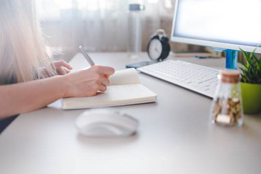 girl writes in a notebook, draws up a schedule for the week