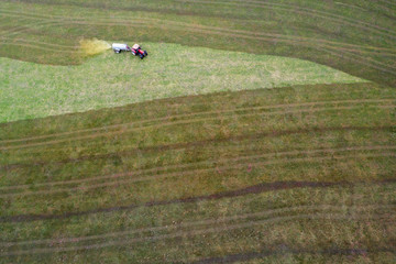 Fototapeta premium a farming machine spraying cow dung on a field from above