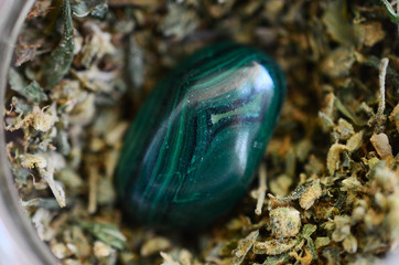 Ground up marijuana flower, malachite healing crystals. Green healing stone and polished malachite. Macro photography of cannabis. Cannabis trim in glass bowl. Natural lighting of medical hemp flower 