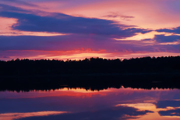 crimson colorful sunset over a forest lake