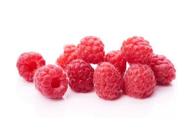 Lots of red juicy raspberries on a white background
