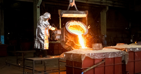 Smelting orange metal in a metallurgical plant. Liquid iron from the ladle