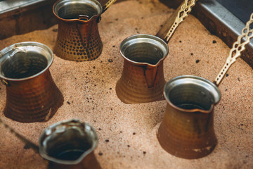 Making traditional black Turkish coffee or espresso in the sand in a special Turk.