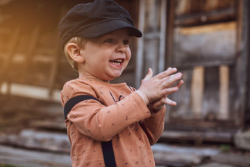 Portrait of a boy dressed in pants with suspenders , against a background of nature.