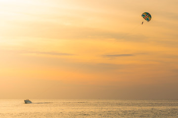 Tourists para-sailing in sunset time at Phuket Beach, Thailand