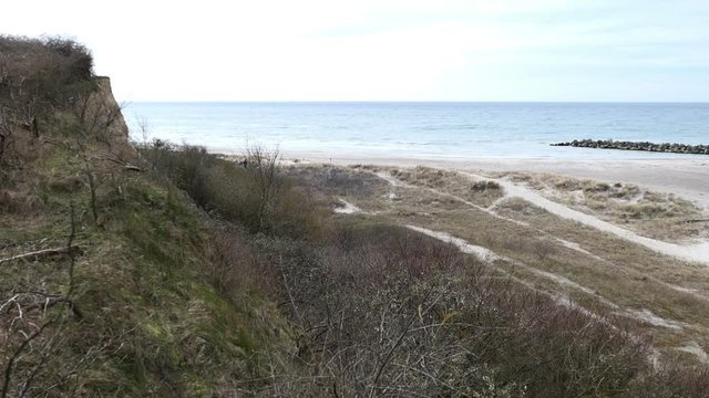 Aerial view from coast cliff of Ahrenshoop Baltic sea down to beach. People walking along.
