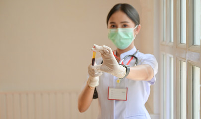 Nurse wearing gloves with a front blood test tube, Concepts examining covid-19 virus infection.