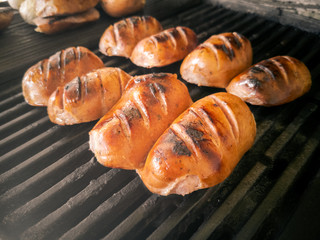 Four mouth-watering traditional bavarian Knackwursts from Regensburg cut in half roasted on cast iron grill grate