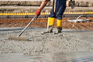 bricklayer who level the freshly poured concrete to lay the foundations of a building