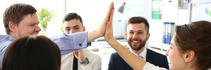 Group of businessman and businesswoman celebrating victory and teamspirit giving high five in air...