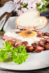 Fried egg with chopped sausage.