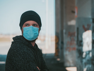 Portrait Of A Hipster Man In A Medical Mask For Protection Against Influenza Virus Or Coronavirus Outdoor. Corona Virus Pandemic. Epidemic Viral Respiratory Syndrome. 2019-nCoV