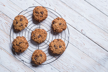 chocolate cookies on a grid on a white wooden board with space for text