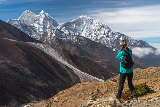 A woman taking picture of Himalaya mountain range, Everest region in Himalaya mountain range in Nepal