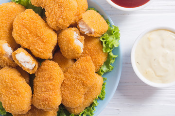 Chicken nuggets in plate on rustic background