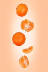 Falling mandarins isolated on an orange background with clipping path as package design element and...