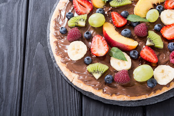 Fruit pizza with nut nougat cream , fruit and berries