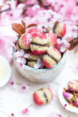 Raw vegan peaches cookies with pink spring flowers on a white table. Peach cookie for vegans. Raw food sweets.
