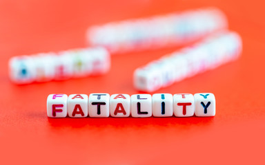 Word fatality made out of colorful beads on red background